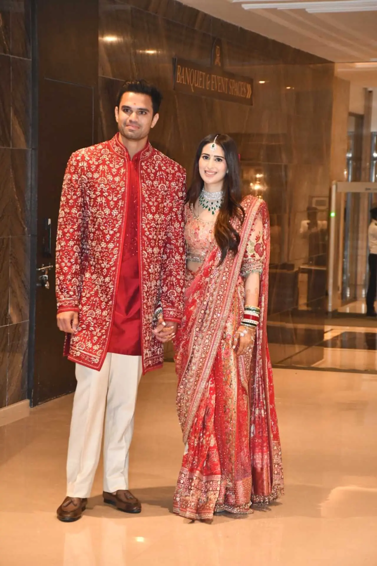 The newlyweds came out to greet the paps and pose for cameras as they radiated the wedding glow twinning in matching red outfits.